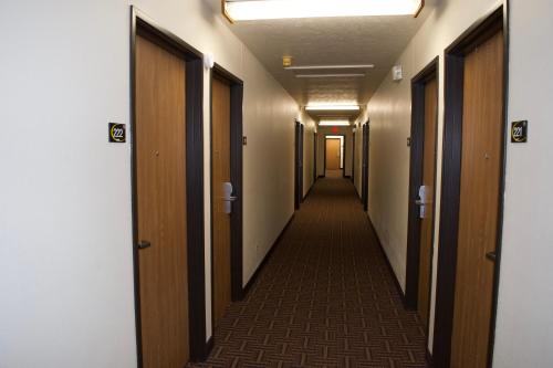 a corridor of a hallway with wooden doors at AmeriVu Inn and Suites Shawano WI in Shawano
