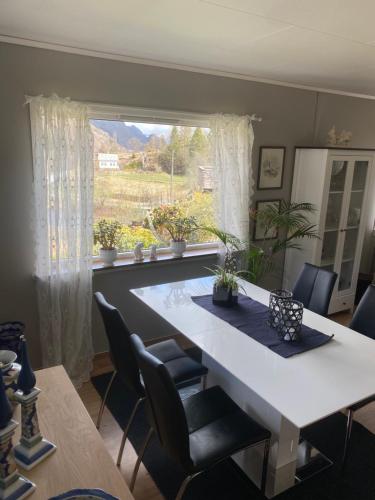 ein Esszimmer mit einem weißen Tisch und einem Fenster in der Unterkunft Sokndal - Cozy vacation home in peaceful surroundings in Ålgård
