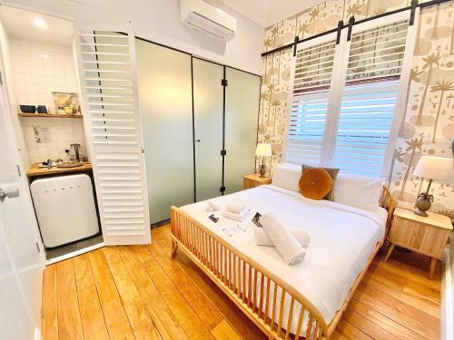 a bedroom with a bed with white sheets and a window at Bayhaven Lodge in Byron Bay