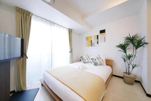 a bedroom with a bed and a large window at Green Sea Oshiage in Tokyo