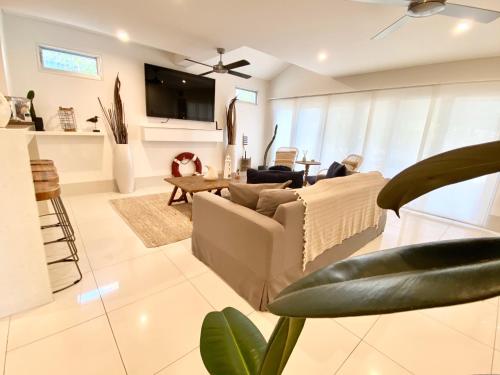 a living room with a couch and a table at Bayhaven Lodge in Byron Bay