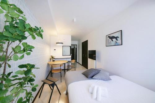 um quarto com uma cama e uma mesa com cadeiras em Green Sea Oshiage em Tóquio