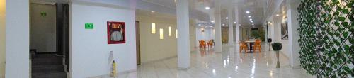 a hallway of a building with tables and chairs at Hotel Paradise del Cafe in Pereira
