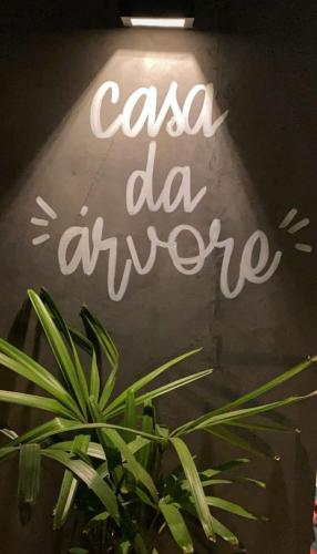 Znak z napisem "casa da ayume" obok rośliny w obiekcie Casa da Árvore espaço Vila da Serra w mieście Nova Lima