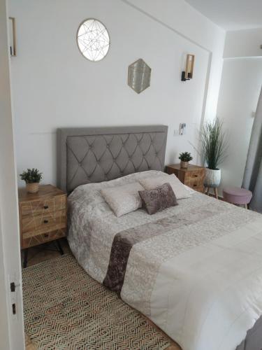 a bedroom with a large bed with a gray headboard at Melanos Residence 2 bdrm townhouse with private pool in Khlorakas