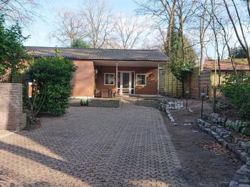 a house with a brick driveway in front of it at Charming Holiday Home in Meijel in a Recreation Park in Meijel