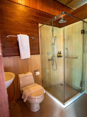 a bathroom with a toilet and a glass shower at 500 Rai Floating Resort in Ratchaprapha