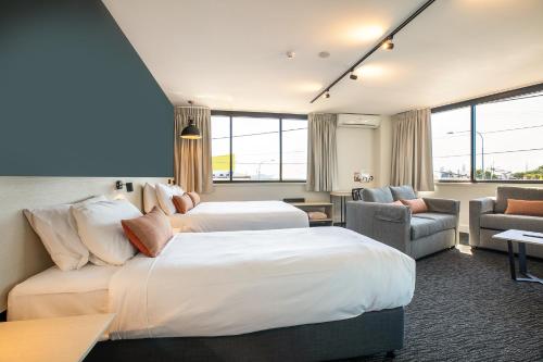 um quarto de hotel com duas camas e um sofá em Nightcap at Chardons Corner Hotel em Brisbane