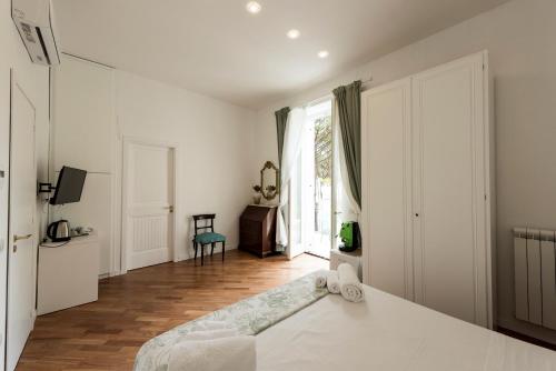a white bedroom with a bed and a window at B&B Casa Maria Vittoria in Torre del Greco