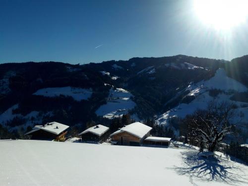 a snow covered mountain with houses on top of it at Almhütte Brandgut in Mühlbach am Hochkönig