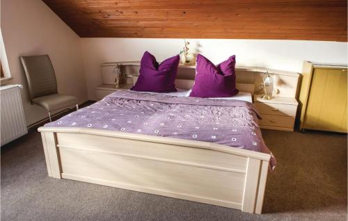 a bedroom with a large bed with purple pillows at Nice Home In Wasungen With Wifi in Wasungen