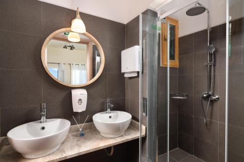 a bathroom with a sink and a mirror and a shower at Rementzo Apartment in Symi