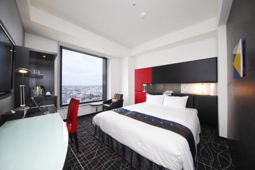 a hotel room with a large bed and a window at New Otani Inn Yokohama Premium in Yokohama