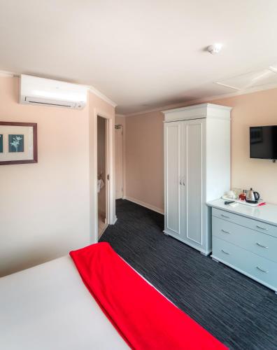 a bedroom with a bed with a red blanket at Florida Park Hotel, Florida Road in Durban