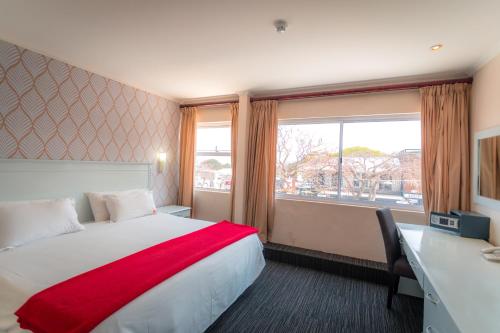 a hotel room with a bed and a desk and a window at Florida Park Hotel, Florida Road in Durban