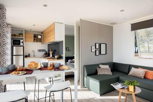 uma sala de estar com um sofá verde e uma mesa em Camping & Bungalows Platja Brava em Pals