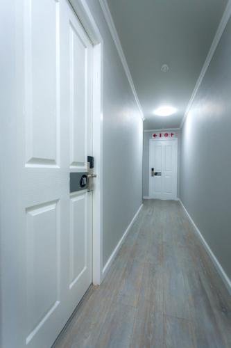 an empty hallway with a white door and wooden floors at Florida Park Hotel, Florida Road in Durban