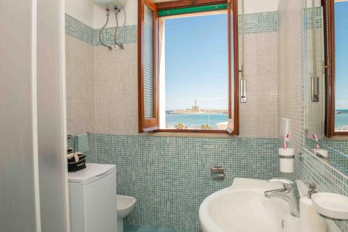 La salle de bains est pourvue d'un lavabo, de toilettes et d'une fenêtre. dans l'établissement La Casa del Mare, à Vieste