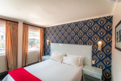 a bedroom with a white bed with a red blanket at Florida Park Hotel, Florida Road in Durban