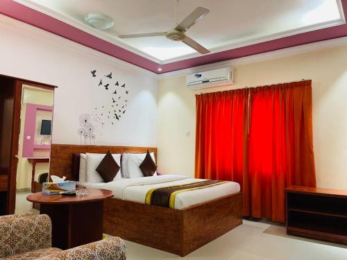 a bedroom with a bed and a red curtain at Al Nakheel Hotel Apartments in Ras al Khaimah