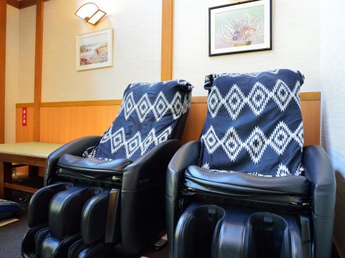 two chairs in a waiting room with blue and white pillows at Jizaiso in Nasu