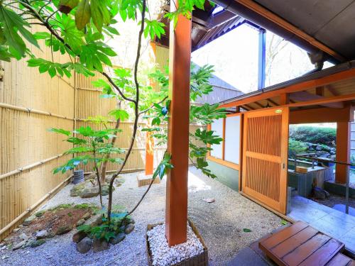 a house with a tree in a courtyard at Jizaiso in Nasu