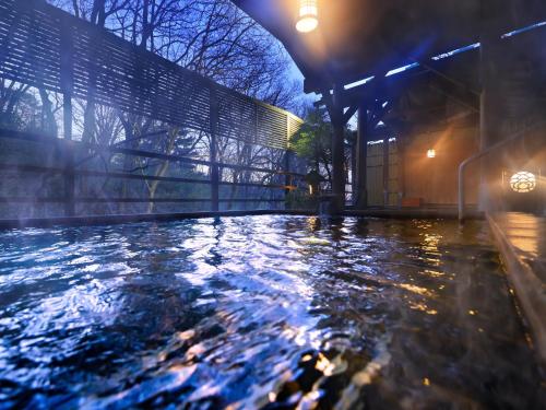 a pool of water next to a building at night at Jizaiso in Nasu