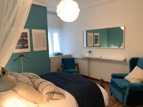 a bedroom with a bed and two blue chairs at SG Apartamentos LA CASA DE LA CATEDRAL VUT47-240 in Valladolid