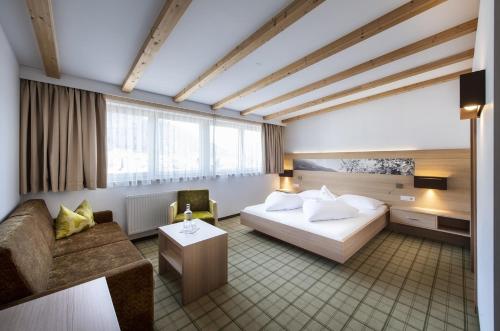 a hotel room with a bed and a couch at Der Mohrenwirt **** in Burgusio