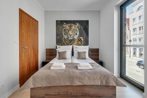 1 dormitorio con 1 cama con una pintura de un tigre en Downtown Apartments Perfect View Symfonia en Gdansk