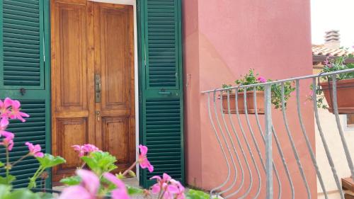 a green door on a building with flowers at La Casa di Rosa in Rio Marina