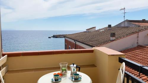 a table on a balcony with a view of the ocean at La Casa di Rosa in Rio Marina