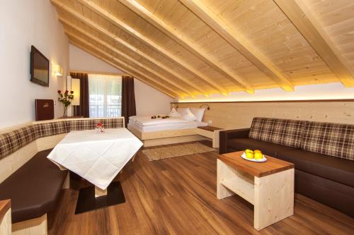 a living room with a couch and a table at Apartments Aghel ***S in Selva di Val Gardena