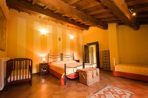 ein Schlafzimmer mit einem Bett und einem Kinderbett in der Unterkunft Il Mulino - beautiful, family-friendly Tuscan villa with fenced pool in Monterchi