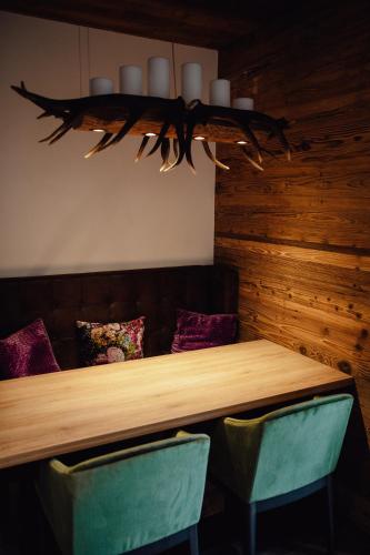a wooden table with two green chairs in a room at Zillertal Juwel in Fügen