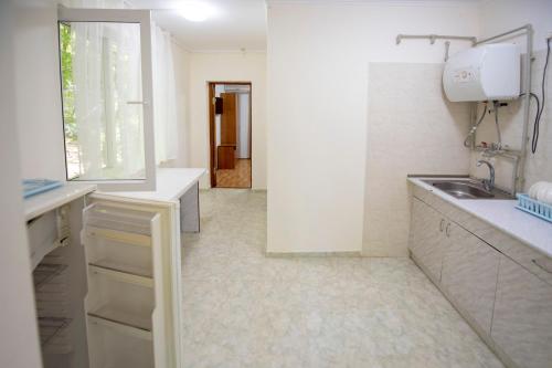 a white kitchen with a sink and a window at Villa Alla in Inal