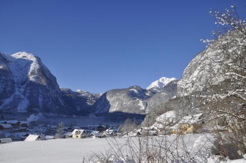 a village in the snow with mountains in the background at Apartment Stadler in Obertraun