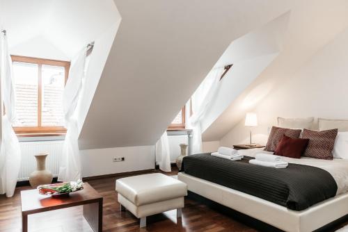 een witte slaapkamer met een bed en een stoel bij Extravaganza in Krakau