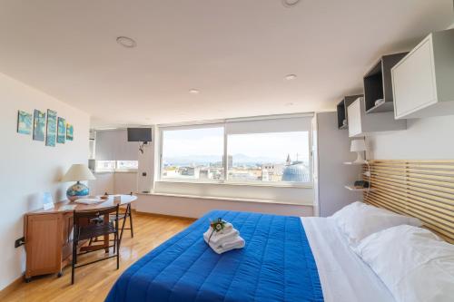 una camera con letto blu, scrivania e finestra di Annunziata Bed and Breakfast a Napoli