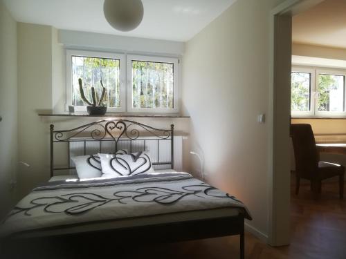 a bedroom with a bed and two windows at Ferienwohnung im Hain in Bamberg