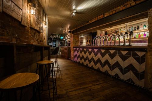 un bar con mesas y taburetes en una habitación en Crux, en Alnwick