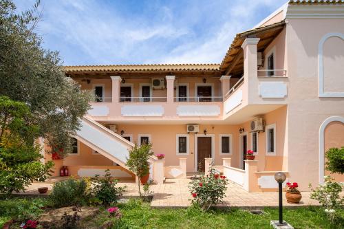 a large house with a staircase in front of it at Nikos Pool Apartments - Upper Floor in Sidari
