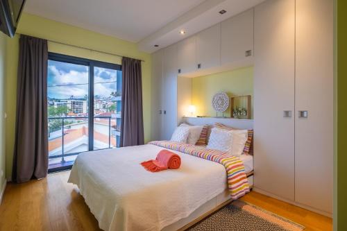a bedroom with a bed and a large window at Green Apartment in Funchal