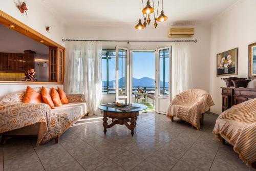 a living room with a couch and a bed and a table at Melisses Sea View House in Plaka Milou