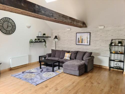 a living room with a couch and a table at The Studio in Farmborough