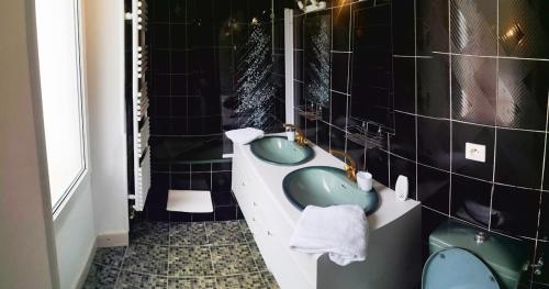 a bathroom with two green sinks and a tub at Icerock Hotel in LʼArgentière-la-Bessée