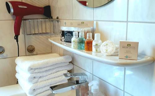 a bathroom with a sink with towels on a shelf at Ferienwohnungen Saida Wohnung 5 in Norden