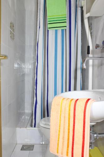 a bathroom with a toilet and a shower with a towel at Apartments Slaven in Podgora