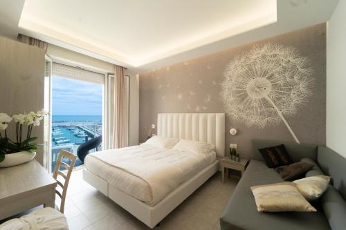 a bedroom with a bed and a desk and a window at Hotel Stella D'Oro in Rimini