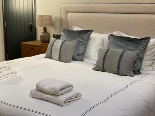 a white bed with towels on top of it at The Merchant's Yard in Tideswell